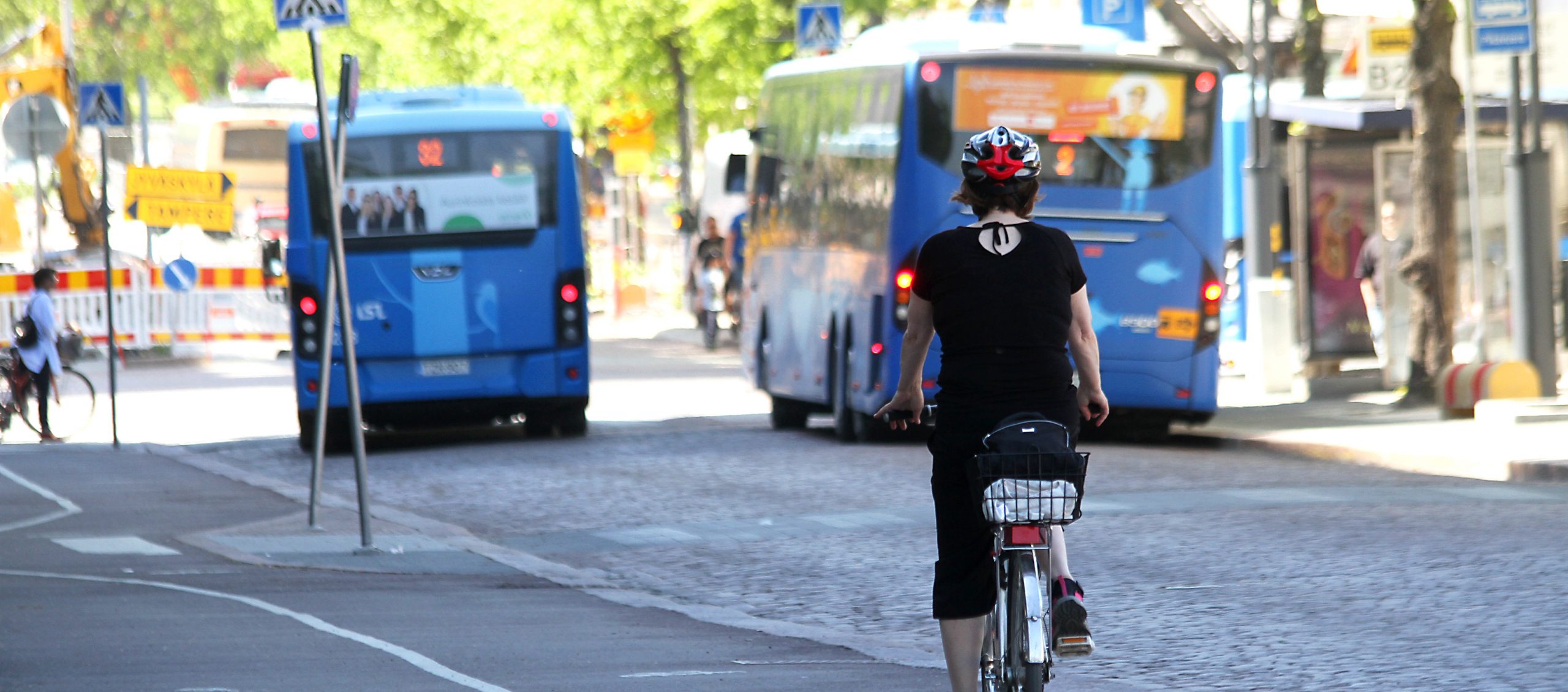 Kuva, jossa busseja ja pyöräilijöitä Lahdessa